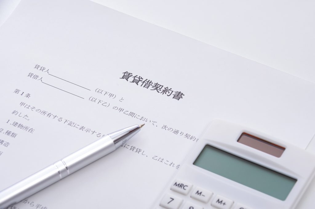 「賃貸借契約書」と書かれた書類、ペン、および電卓