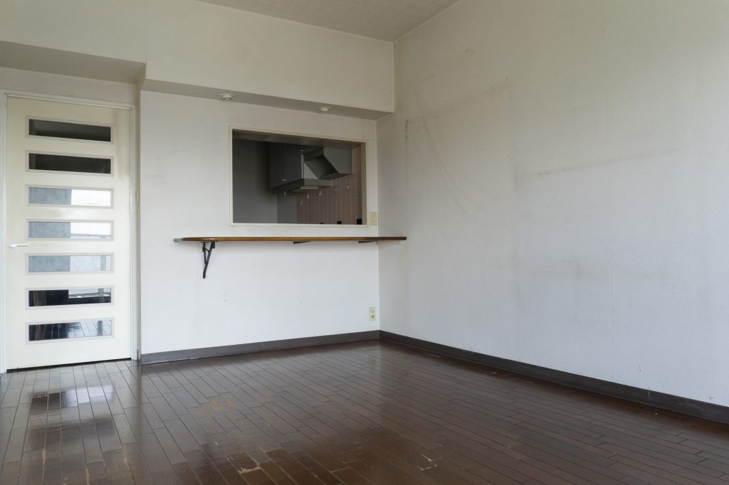 濃い色のフローリングと白壁のマンション室内