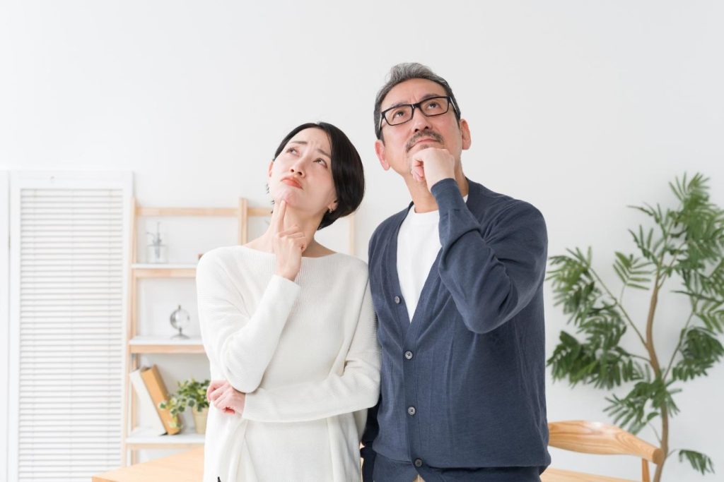 顎に手を当てて考え込むミドル夫婦