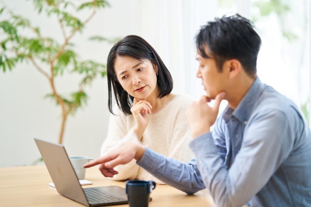 パソコンで調べものをする夫婦。